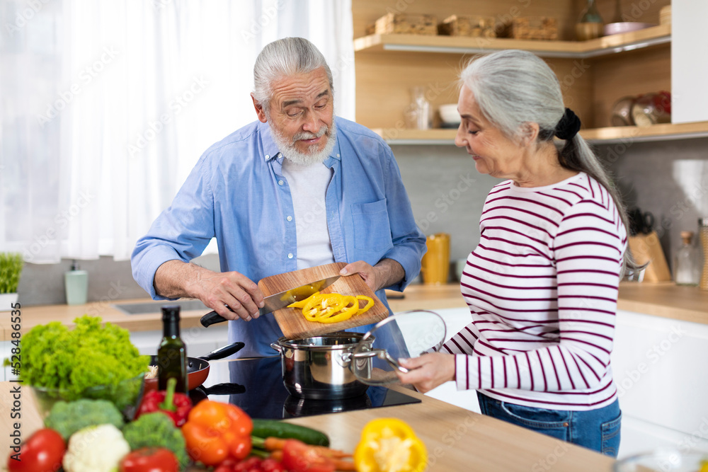 Healthy Eating For Seniors. Portrait Of Elderly Spouses Cooking Together In Kitchen Healthy Eating For Seniors. Portrait Of Elderly Spouses Cooking Together In Kitchen