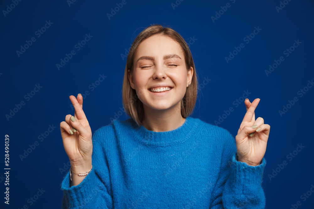 Young hopeful beautiful girl with csossed fingers and closed eyes Young hopeful beautiful girl with csossed fingers and closed eyes