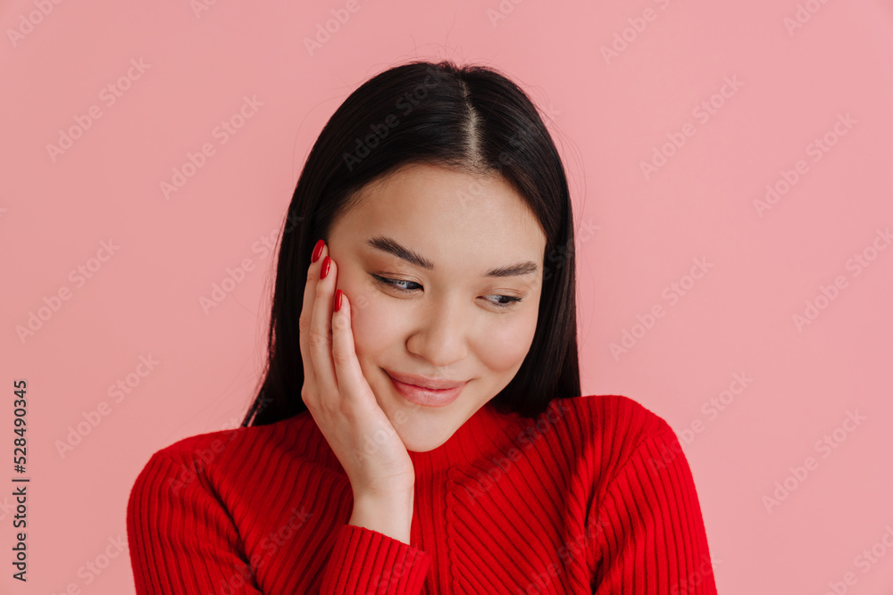 Asian young woman wearing sweater smiling and looking downward Asian young woman wearing sweater smiling and looking downward