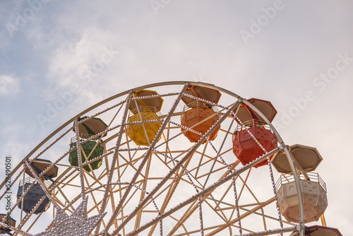 Ferris wheel against the sky. Colorful attractions.