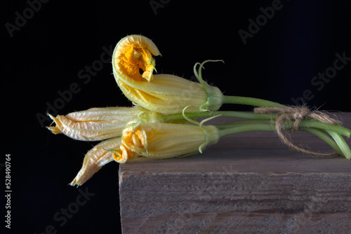 yellow flowers zucchini vegetables on a wooden table
