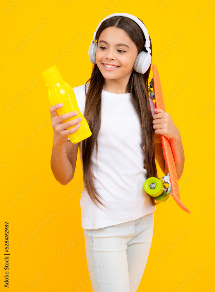 Happy teenager portrait. Teenagers youth casual culture. Teen girl with skateboard and headphones over isolated studio background. Teenager in fashion stylish clothes. Smiling girl. Happy teenager portrait. Teenagers youth casual culture. Teen girl with skateboard and headphones over isolated studio background. Teenager in fashion stylish clothes. Smiling girl.