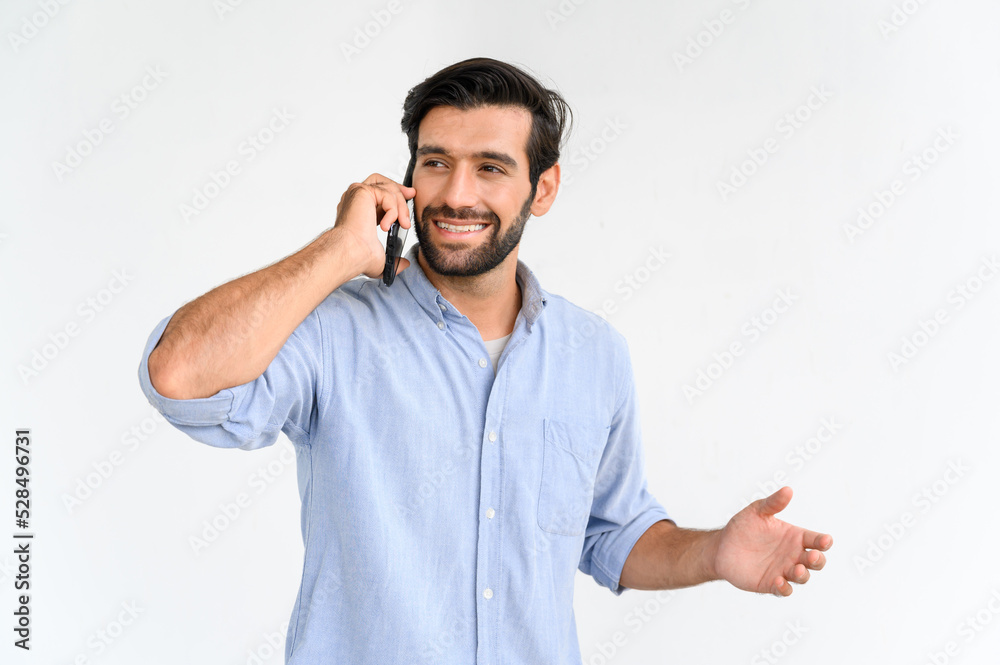 Portrait of smiling macho bearded guy in blue t-shirt using smartphone standing over white background. Portrait of smiling macho bearded guy in blue t-shirt using smartphone standing over white background.
