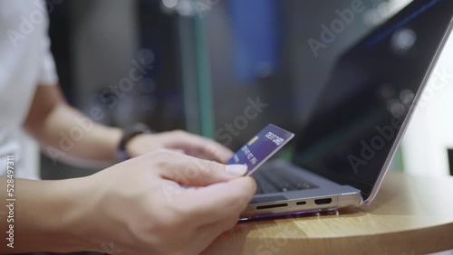 Close up a credit card user look at credit card numbers filling out on website page, online purchasing tickets reservations, member points collection, customer hands holding credit card laptop