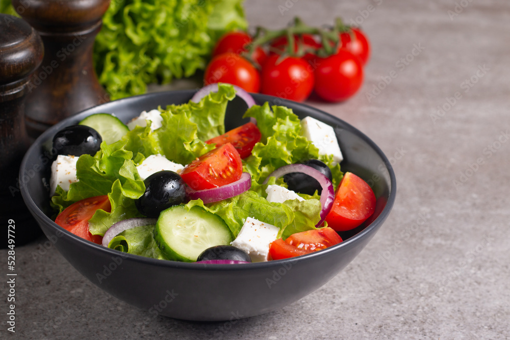 Fresh Greek salad with delicious rucola, spinach, arugula, feta cheese, cucumber, red onion and cherry tomato Healthy and diet food concept.