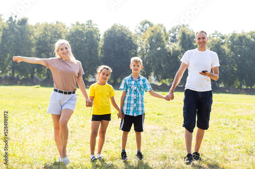 Fototapeta Naklejka Na Ścianę i Meble -  Happy family enjoying life together at meadow outdoor.