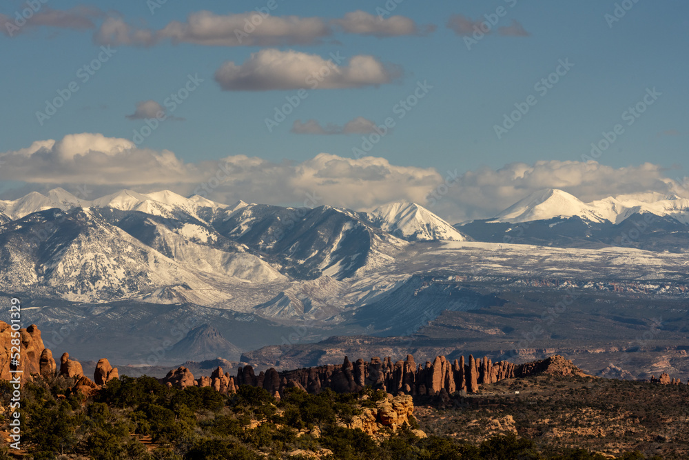 Snow Covered La Sal Mountains Loom Over Firey Furnace