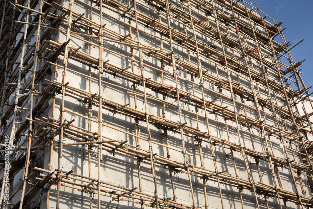 bamboo scaffolding for cement plastering in the construction of a new grand condominium