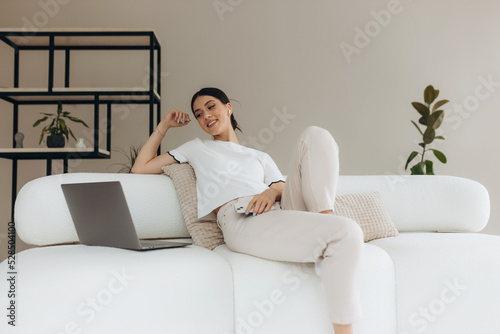 Young woman using her gadgets and relaxing at home