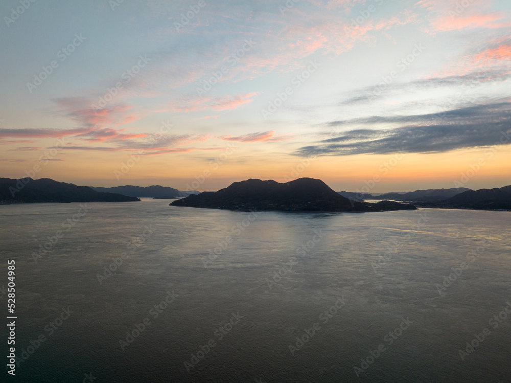 Aerial view of small coastal island silhouetted against pre-sunrise sky