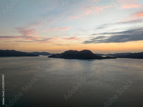 Aerial view of small coastal island silhouetted against pre-sunrise sky