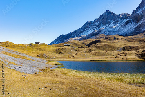 Fototapeta Naklejka Na Ścianę i Meble -  Alpine lake in autumnal guise at Pass Alpisella in Valtellina, Italy