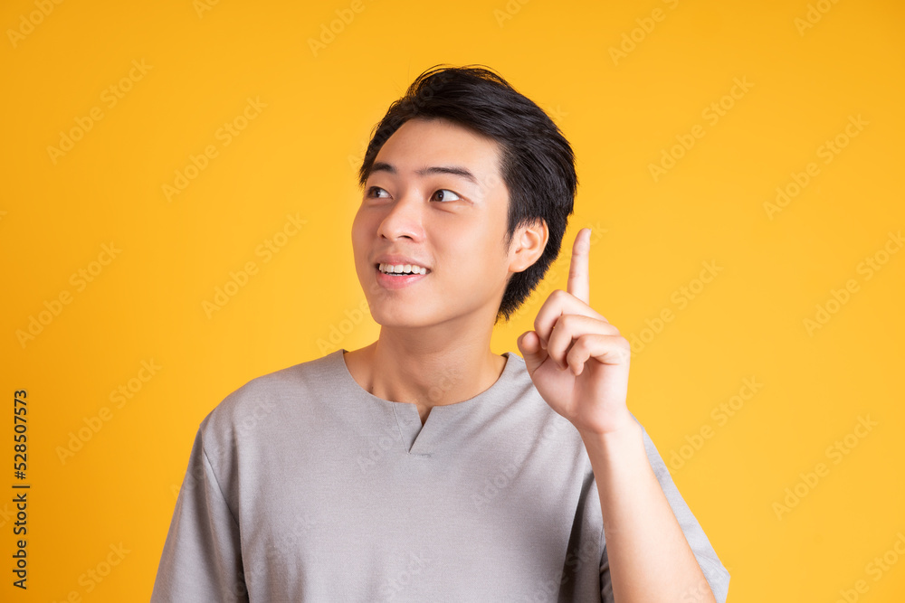Asian young man posing on a yellow background Asian young man posing on a yellow background