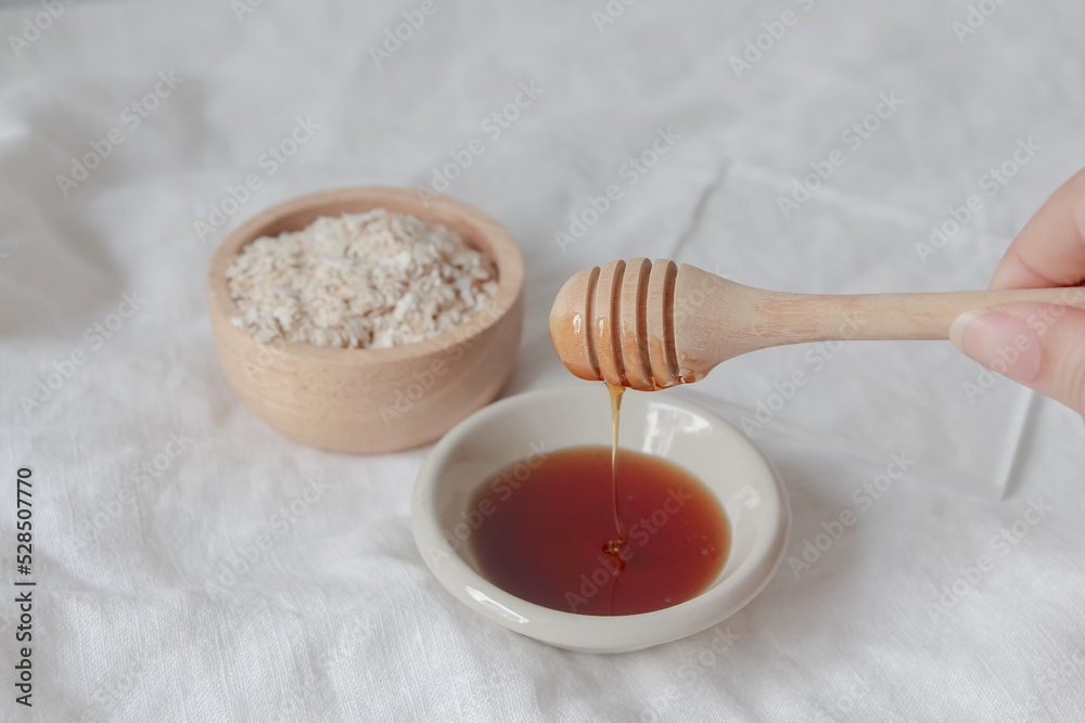 Fototapeta premium Natural ingredients for homemade face mask, oat and honey on white background, beauty skincare product concept,