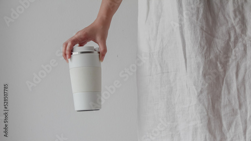 Hand woman holding reusable a drink water cup or coffee cup,  Zero waste, Environmental friendly, green living lifestyle.