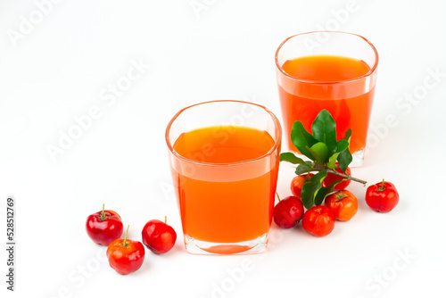 Acerola or barbados cherry juice in glass with fresh acerola cherry fruits isolated on white background.