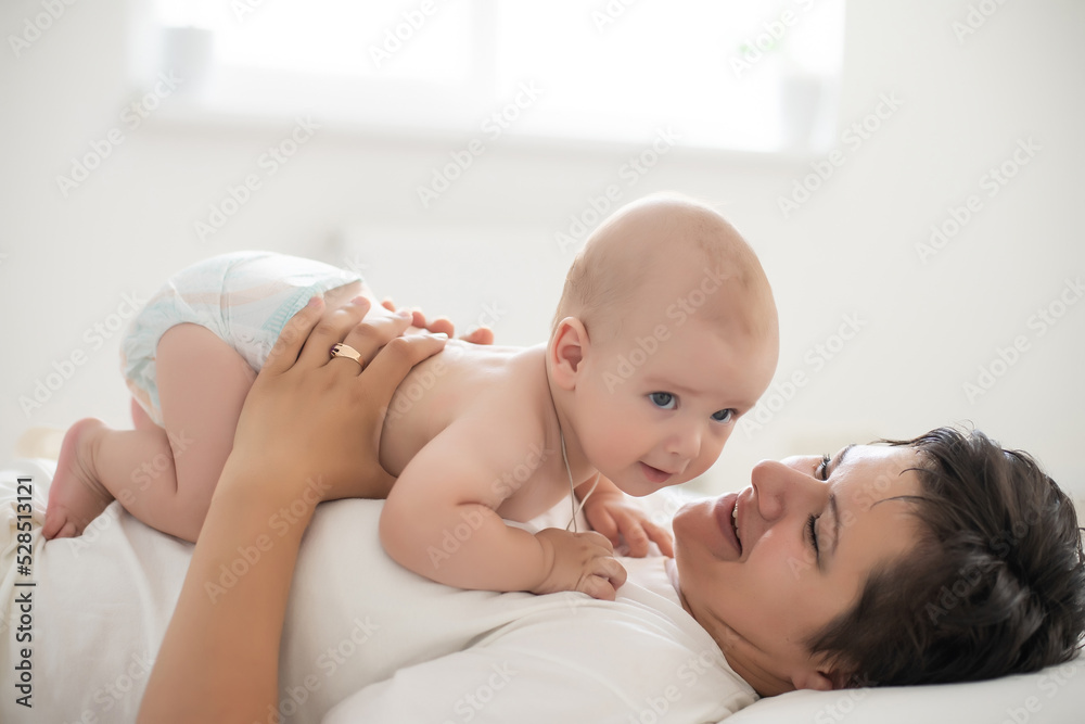 happy mother with baby on bed happy mother with baby on bed