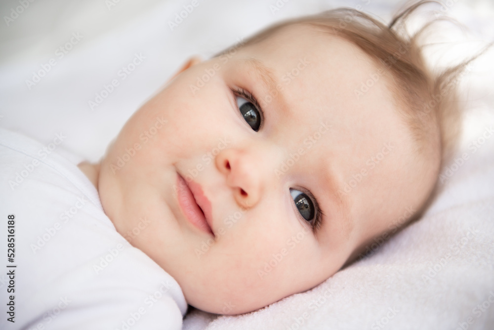Portrait of a six-month-old baby girl, who lies on her back in her crib. Portrait of a six-month-old baby girl, who lies on her back in her crib.