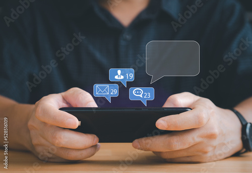 Chat or email sending concept. Person communication by chat, sending email to friend or family via smart phone with two hand typing the text messaging on wood table. Modern Digital technology online.