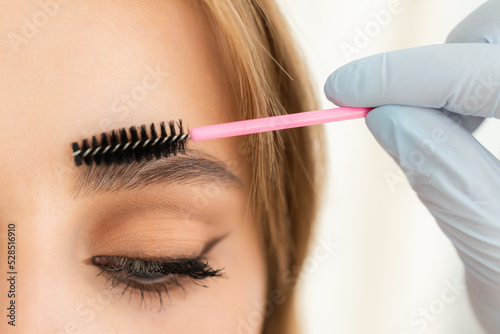 Eyebrows of girl after plucking and haircut close-up. The makeup artist will do permanent eyebrow makeup. Makeup and cosmetology concept