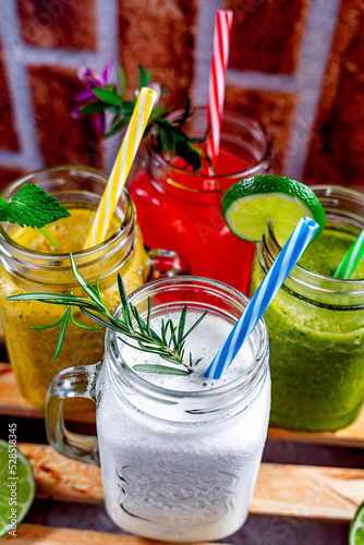 summer drink in a jar of fresh mint and a glass of pineapple, lemon, cucumber and basil. fruit juices with lemon slice and straws  photo