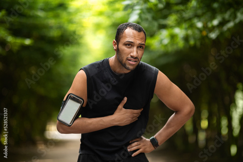 African american sportsman having heart pain, training outdoors