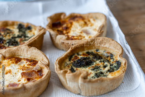 Four baked quiches on an aluminum tray