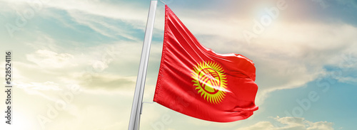 Kyrgyzstan national flag cloth fabric waving on the sky - Image photo