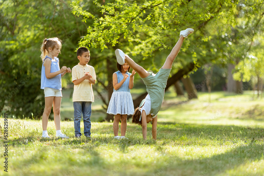 Obraz premium Group of asian and caucasian kids having fun in the park