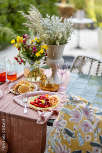 Breakfast on beautifully decorated table with flowers in garden