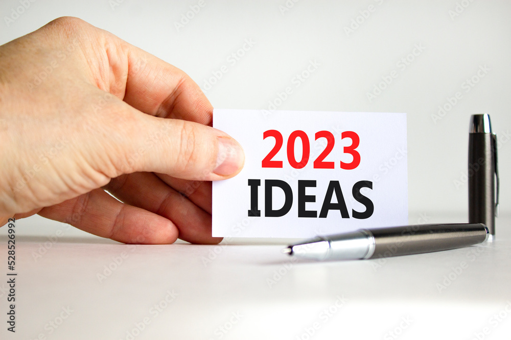 2023 Ideas symbol. White paper with words 2023 Ideas. Businessman hand. Metallic pen. Beautiful white table white background. Business and 2023 ideas concept. Copy space. 2023 Ideas symbol. White paper with words 2023 Ideas. Businessman hand. Metallic pen. Beautiful white table white background. Business and 2023 ideas concept. Copy space.