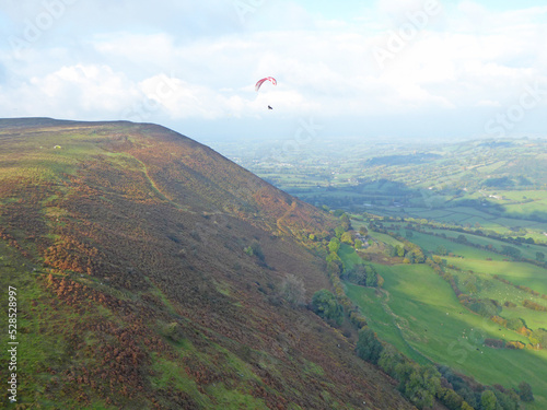 Paragliders flying above the ridge at Pandy, Wales 