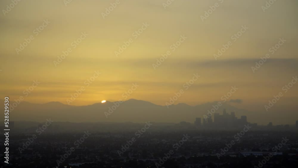 Aerial Lockdown Silhouette Of Downtown By Mountains In City During Sunset - Los Angeles, California Aerial Lockdown Silhouette Of Downtown By Mountains In City During Sunset - Los Angeles, California