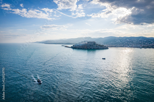 Fotografía aérea de Peñíscola con algunas barcas pesqueras y cielo nublado.