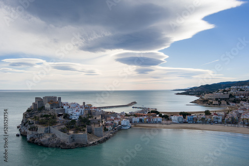 Fotografía aérea de un atardecer en Peñíscola con nubes deformadas por el viento.