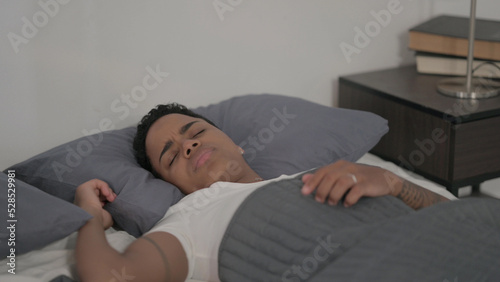 African Woman Feeling Uncomfortable while Sleeping in Bed