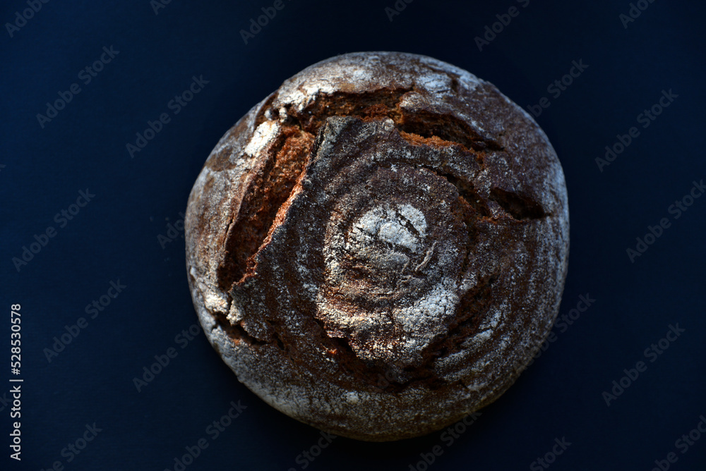 A loaf of black bread on a black background. Delicious black bread close-up. A loaf of black bread on a black background. Delicious black bread close-up.