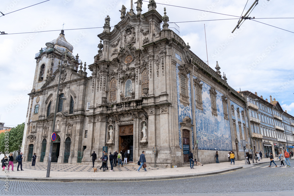 Church of the Barefoot Carmelites in Porto, with the side full of blue and white tiles, on a cloudy day.
