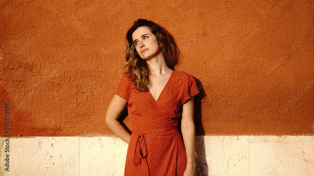 Fototapeta premium young woman thoughtful leaning against a street wall