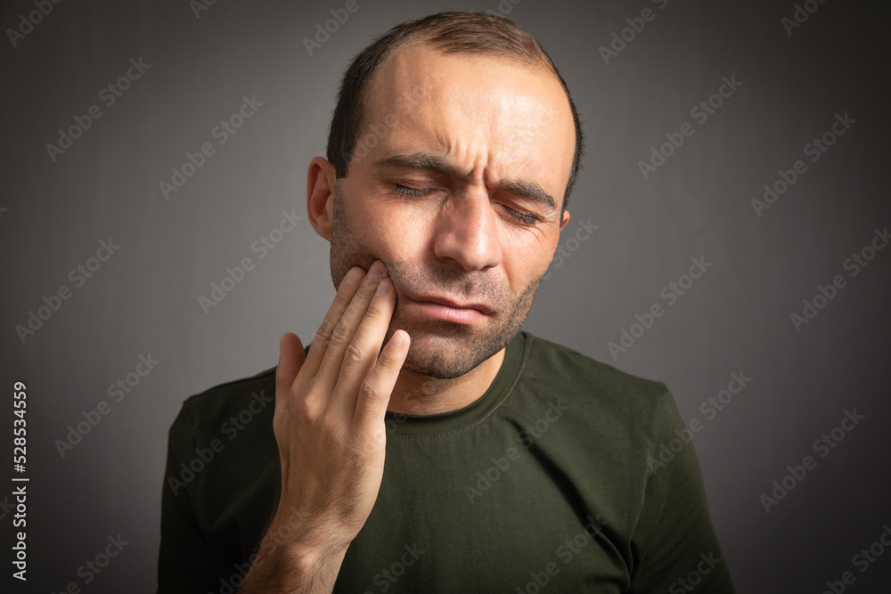 Caucasian man suffering from tooth pain.