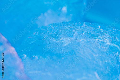 Blue paints on melting ice. Flowing liquid inks. Nature glacier. Creative art process