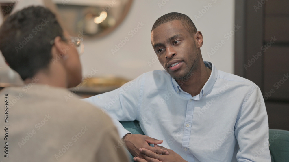 Serious African Woman Talking to African Man on Sofa Serious African Woman Talking to African Man on Sofa