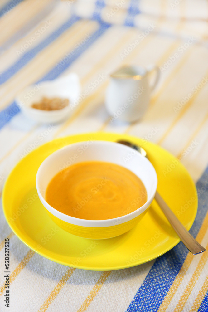 Pumpkin soup, mashed cream soup on a yellow platter with a spoon. Pumpkin soup, mashed cream soup on a yellow platter with a spoon.