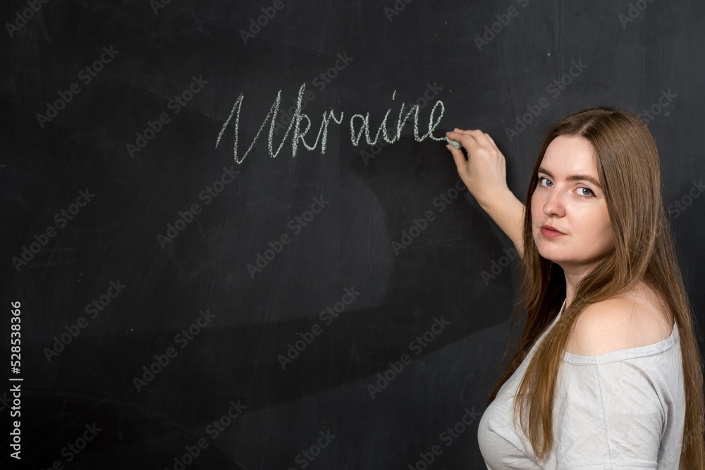 A woman of European appearance writes the word 