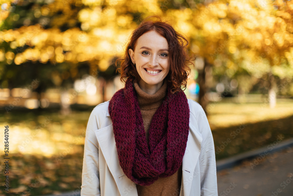 Happy redhead millennial european woman in raincoat with scarf enjoy great weather, free time in city park Happy redhead millennial european woman in raincoat with scarf enjoy great weather, free time in city park