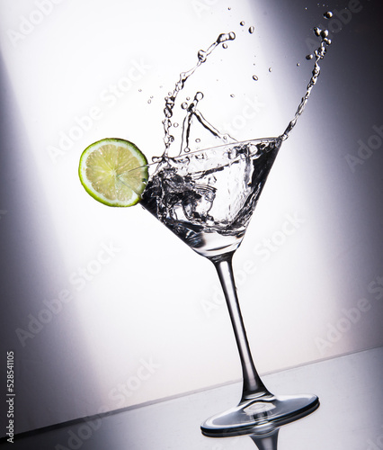Glass with juice, ice and lime on a white gradient background