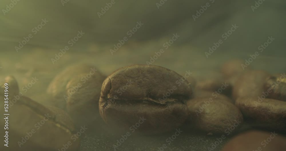 Macro shot of roasting coffee beans, filmed in a dark key the smoke ...