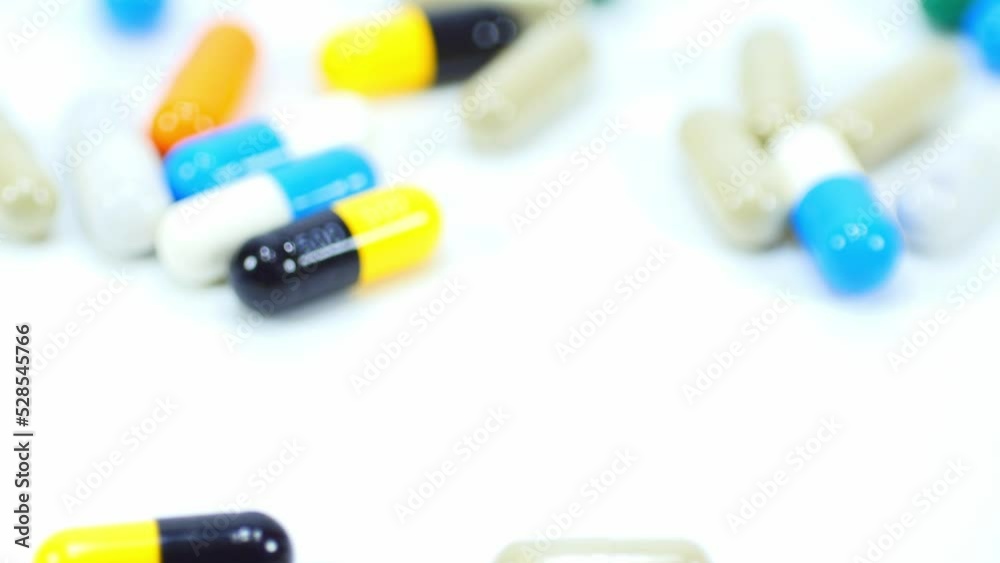 Close up slow motion medicine multi color of pills rotation and pour the drug isolated on white background.Macro video. Close up slow motion medicine multi color of pills rotation and pour the drug isolated on white background.Macro video.