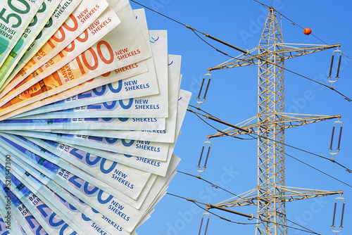 New Israeli shekel banknotes on electric pole background. Energy crisis in Israel, power shortage and increased energy consumption. Electric crisis. High voltage pole on blue sky background