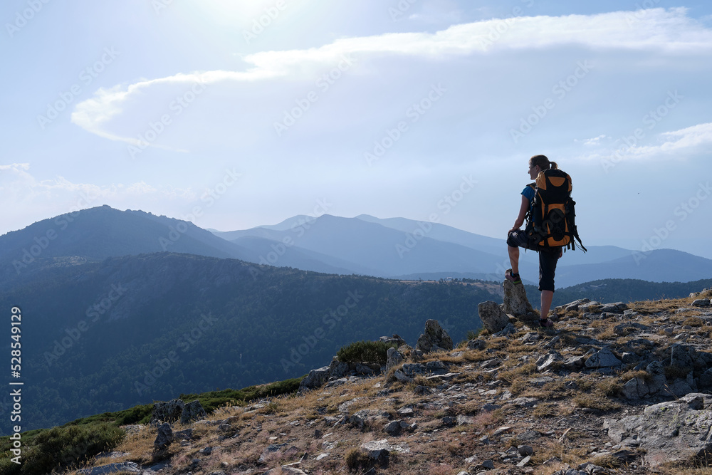 Female traveler with backpack admiring mountains Female traveler with backpack admiring mountains